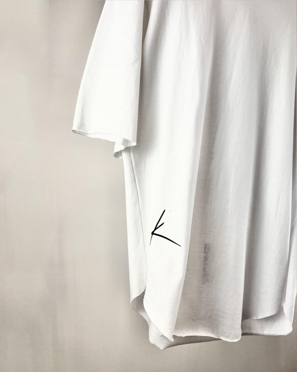 Μπλούζα λευκή μανίκι 3/4 λεπτομέρεια απο το λογότυπο στο πλαινό κάτω της μπλούζας.